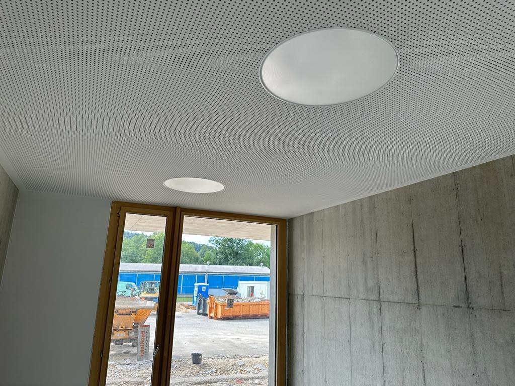Perforierte Deckenfläche mit eingesetzten runden Leuchten.